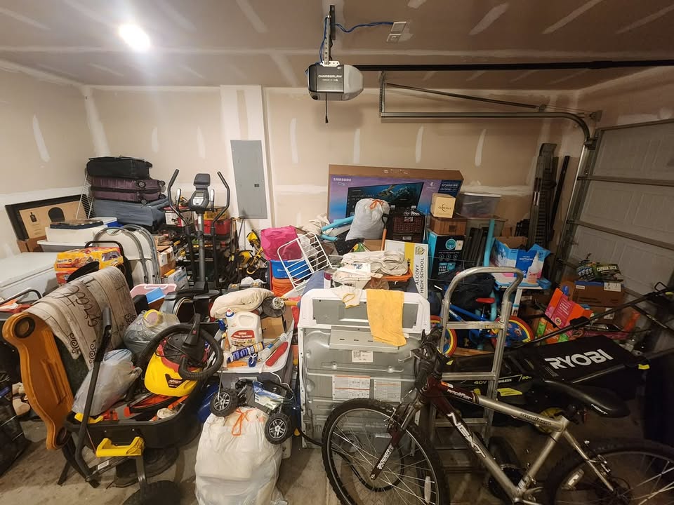 Garage before cleaning, with stored furniture, boxes and household items